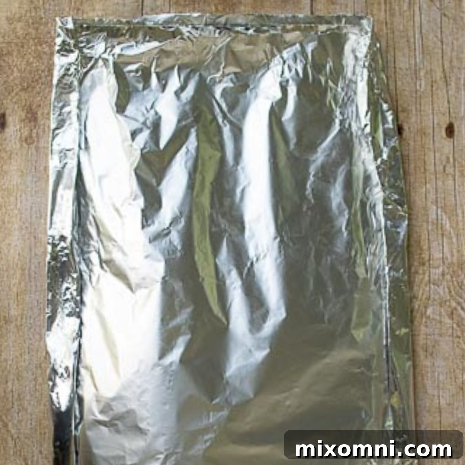 Image demonstrating the proper technique for shaping and sealing a foil packet to create a secure enclosure for grilling.