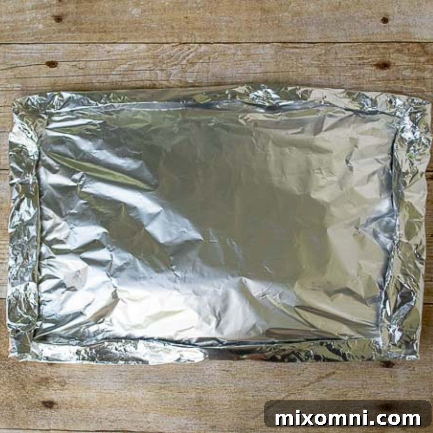 Another image illustrating the careful process of sealing foil packets to ensure all edges are tightly closed for optimal cooking on the grill.