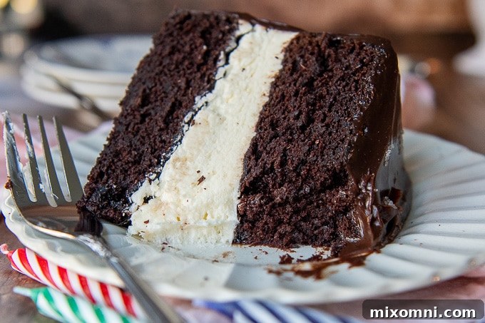 A slice of homemade Hostess-style Ding Dong cake resting on a white plate, with a bite taken out to show its texture.
