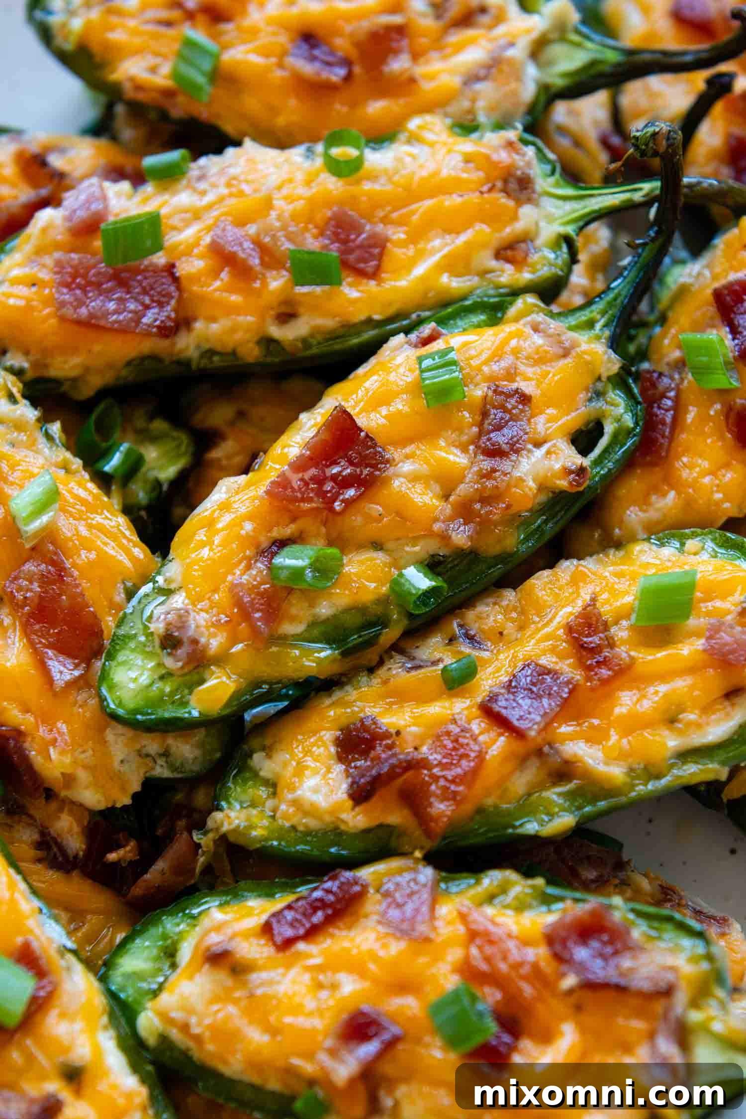Close up of perfectly baked Gluten-Free Jalapeno Poppers with golden cheese and bacon bits, ready to be devoured.
