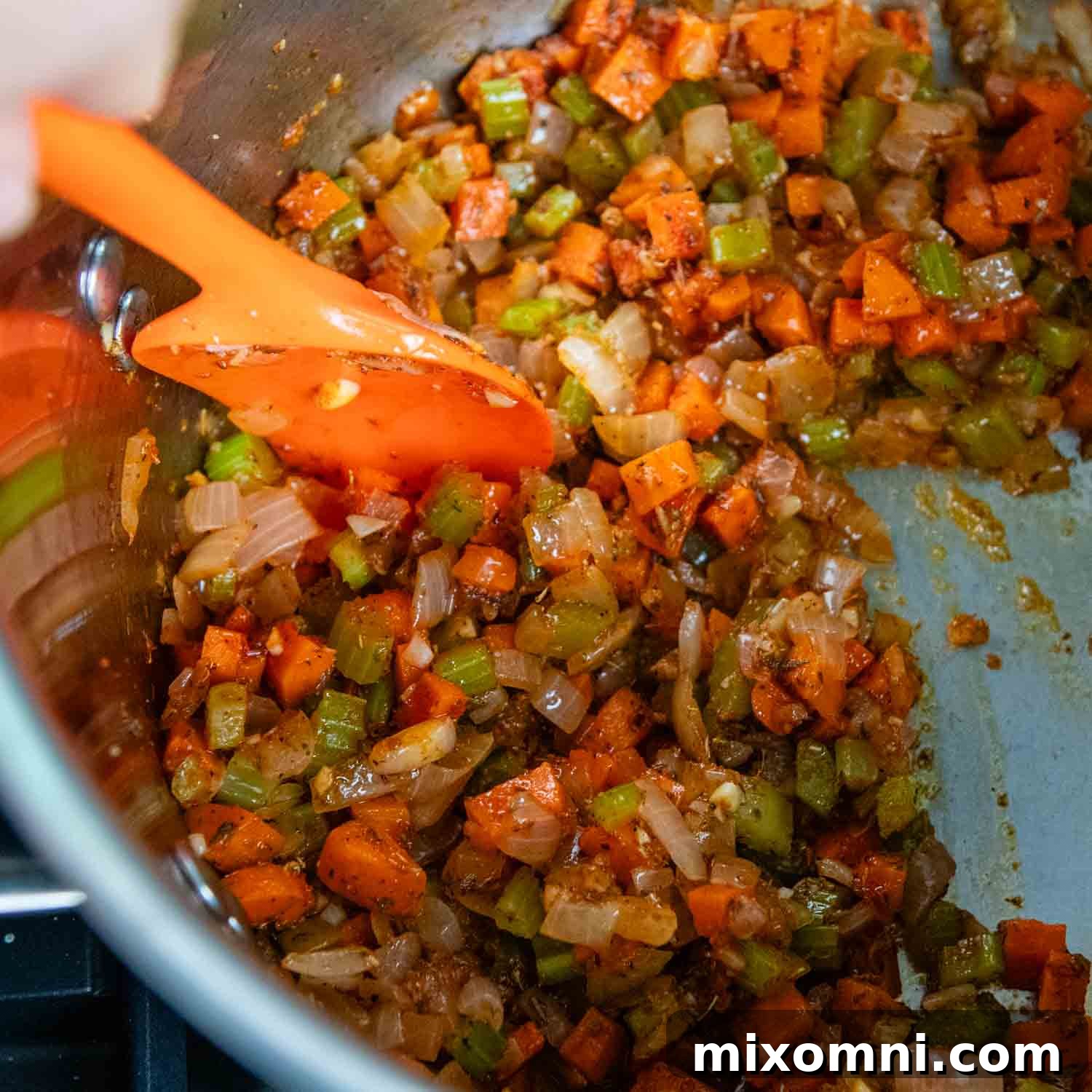 Tomato paste, garlic, and spices being added to the sautéed vegetables in the pot.