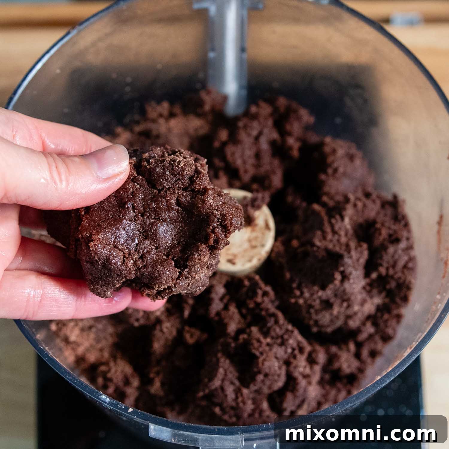 A hand gently pressing and checking the consistency of the Basler Brunsli cookie dough.