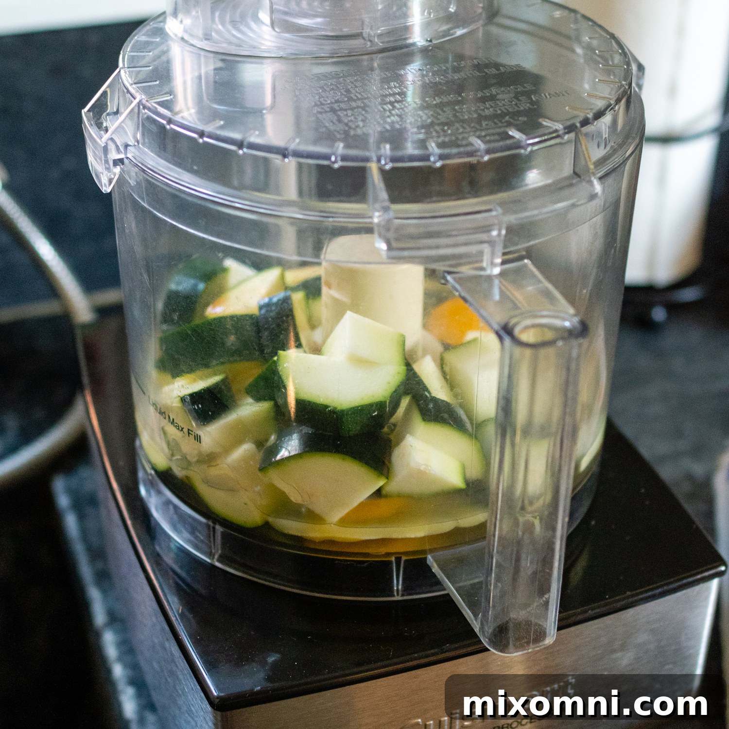 Large chunks of fresh zucchini ready to be processed in a food processor.