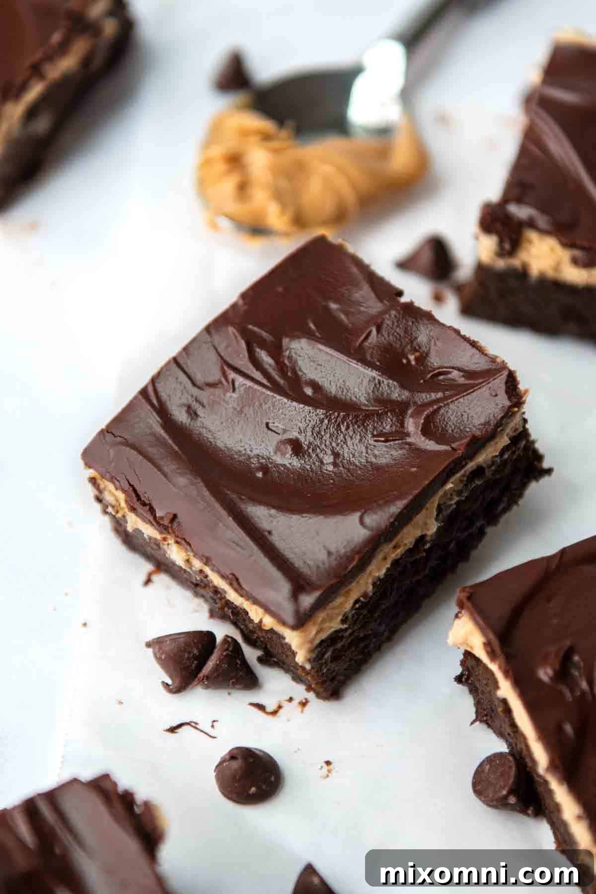A close-up view of the glossy, shiny chocolate glaze perfectly topping a zucchini brownie, showcasing its smooth texture.