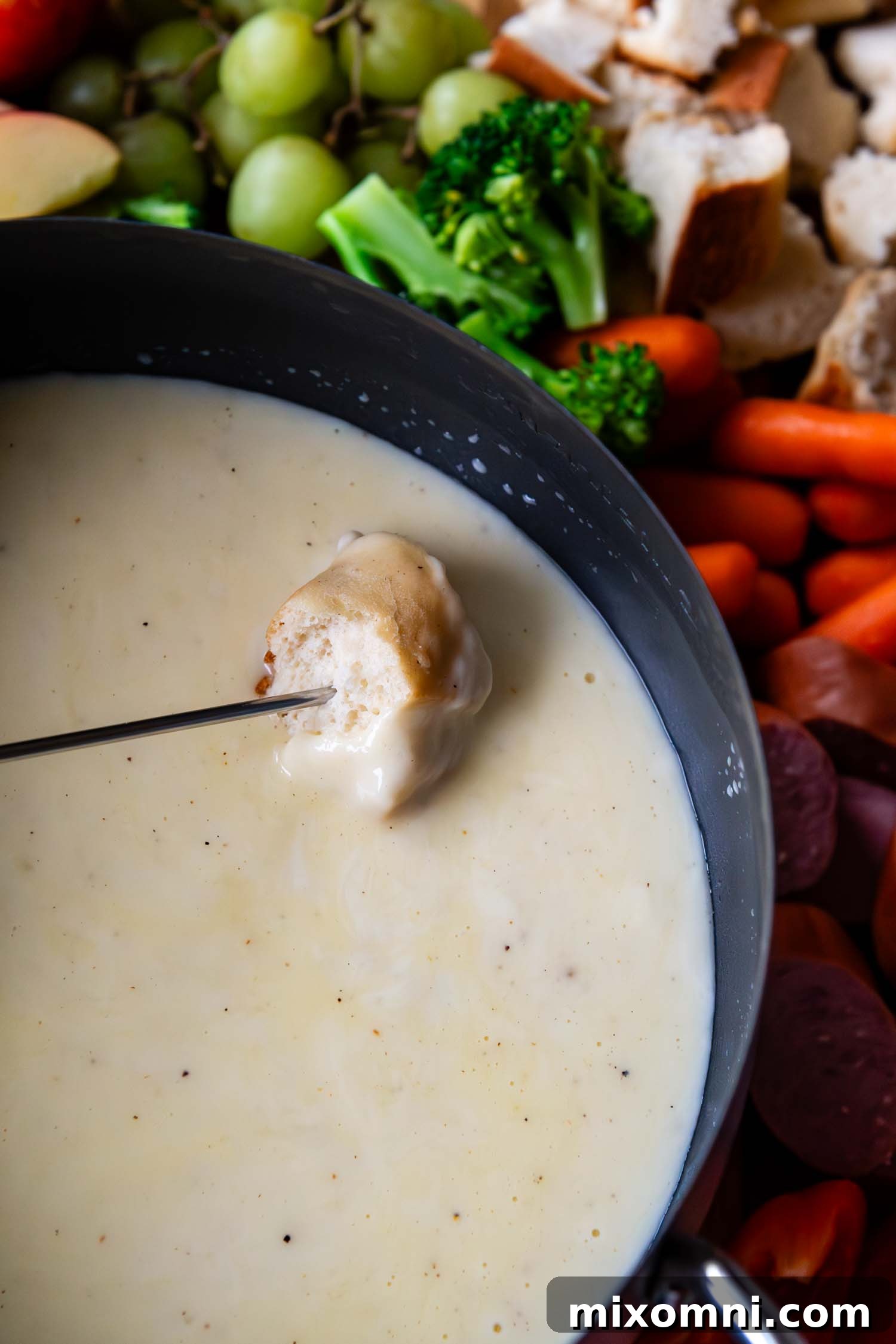 Bread being dipped into a pot of cheese fondue.