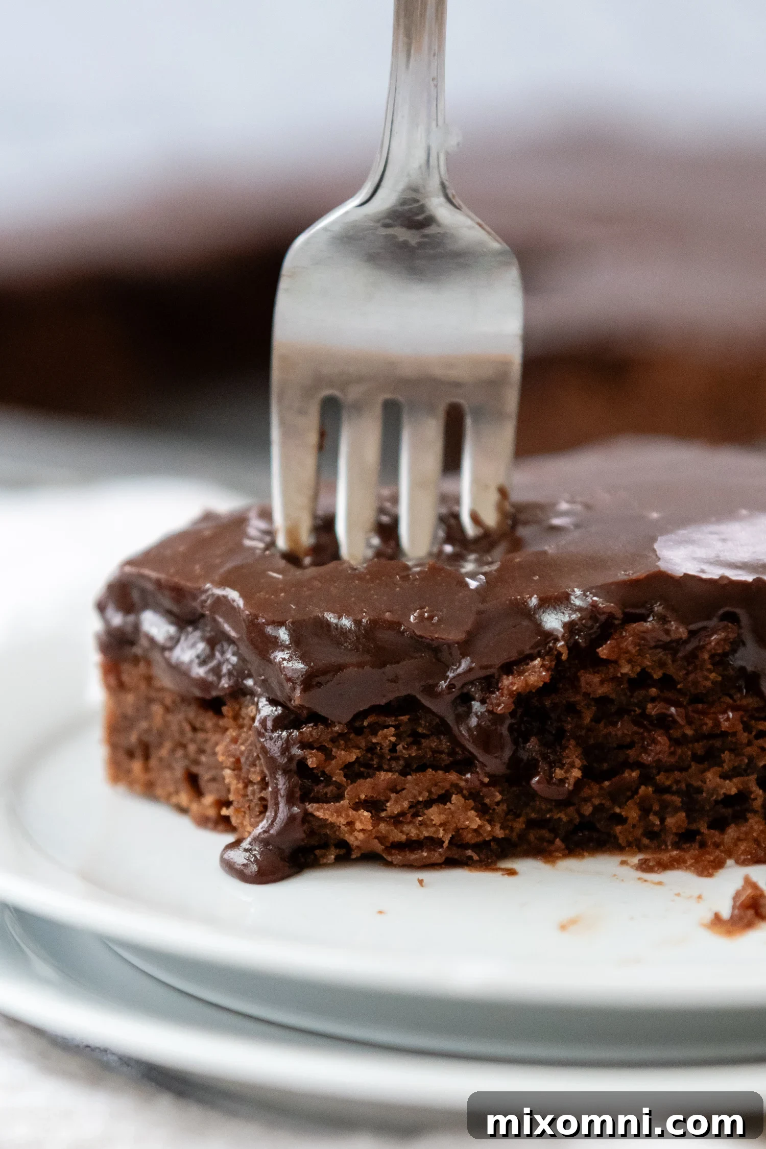 Gluten-Free Texas Sheet Cake on a white plate with a fork, ready to be enjoyed.