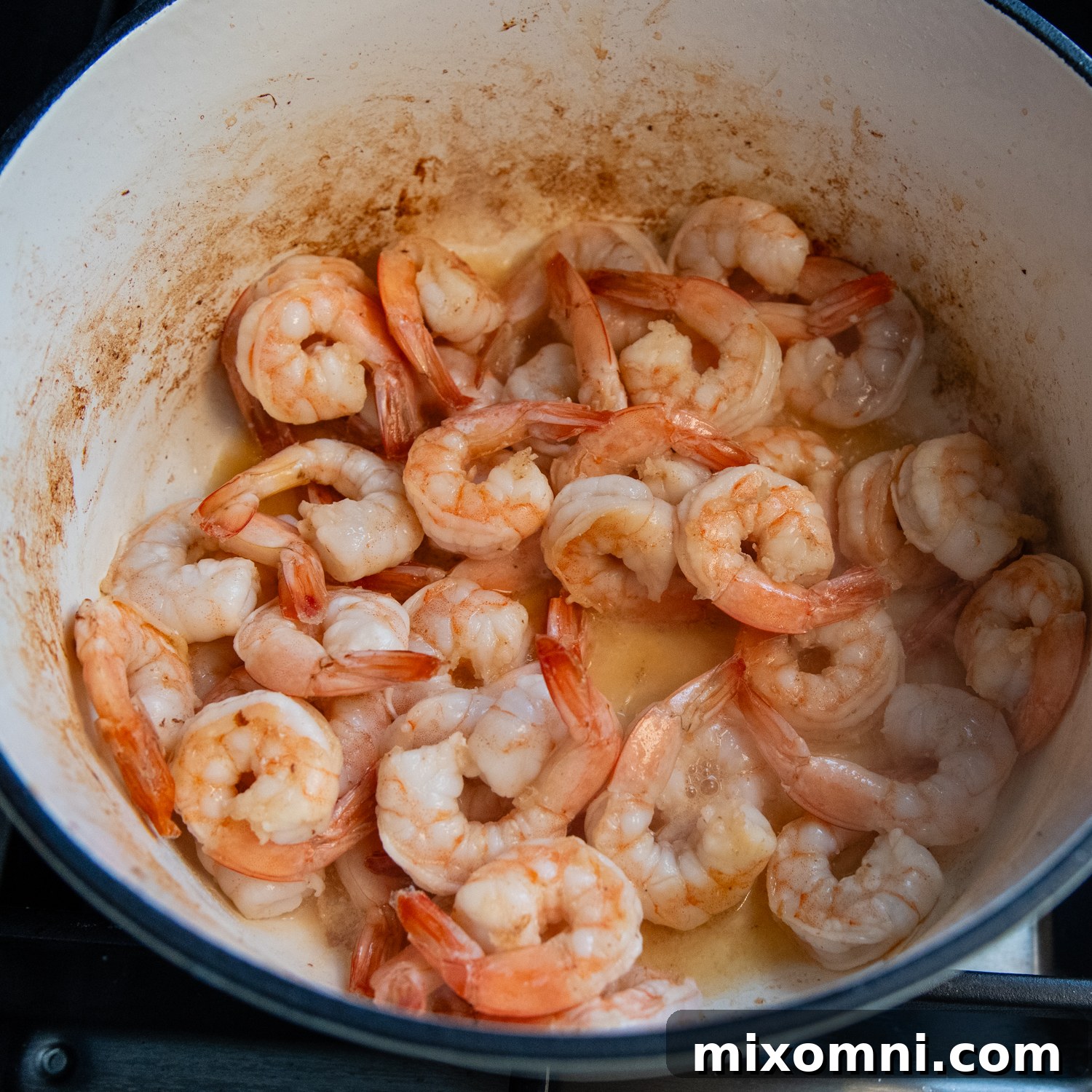 Shrimp cooking until pink in the same pot, ready to be set aside.