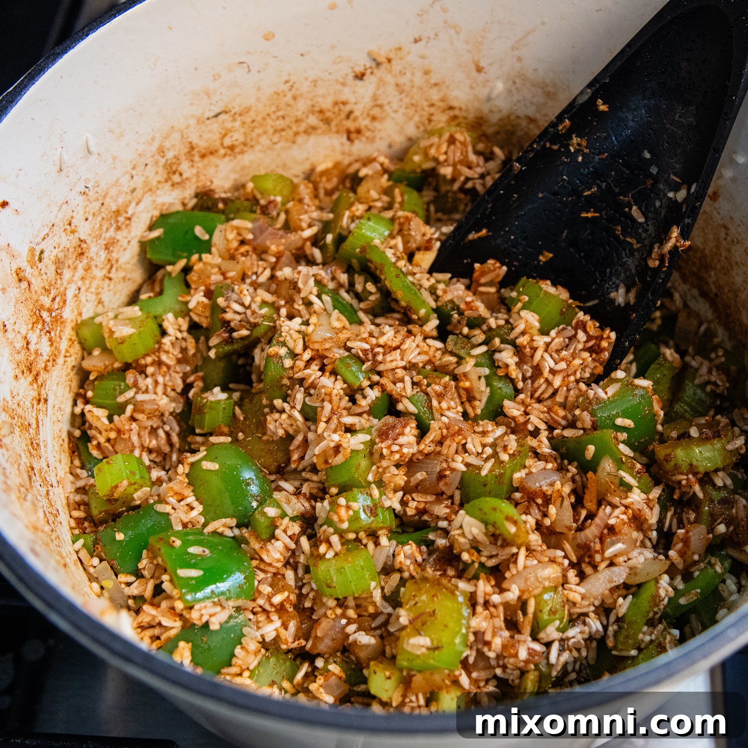 Rinsed rice and homemade Cajun spices added to the sautéed vegetables.
