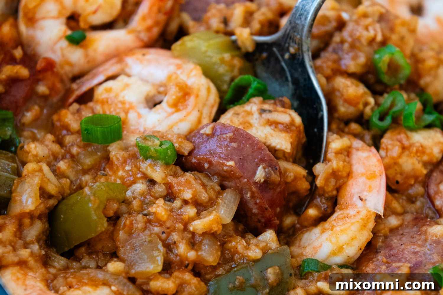 Close-up of a perfectly cooked, vibrant Gluten-Free Jambalaya in a pot, garnished with green onions.