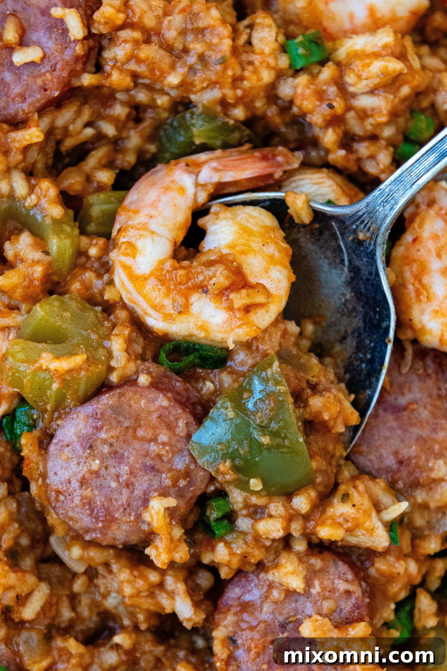 Close-up of a spoonful of Gluten-Free Jambalaya with chicken, sausage, and shrimp.