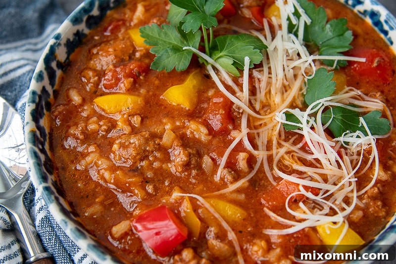 Close-up view of a bowl of homemade stuffed pepper soup, showing the rich texture of the beef, peppers, and rice.