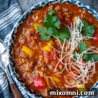Overhead shot of stuffed pepper soup in a blue bowl with blue napkin next to it