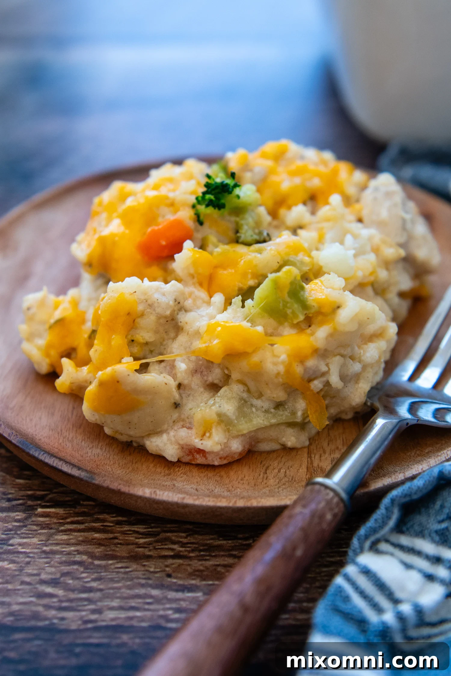 A generous serving of rich, creamy Gluten-Free Chicken Rice Casserole, garnished and ready to enjoy on a rustic plate with a fork.