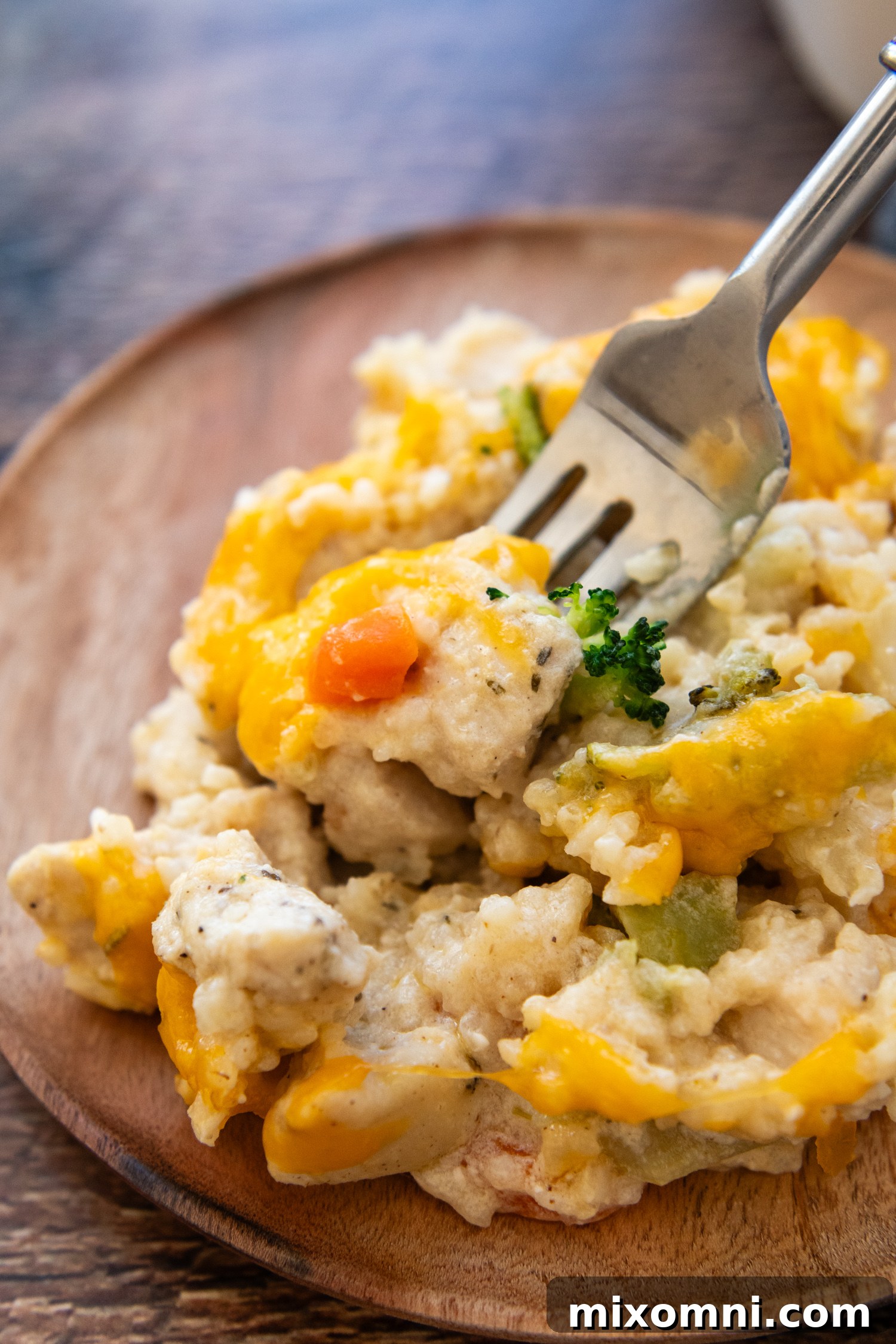 A close-up shot of a fork holding a delicious bite of Gluten-Free Chicken Rice Casserole, featuring a visible piece of tender carrot.