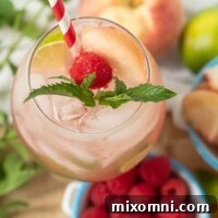 looking down on top of a raspberry peach mojito with fresh mint sprig and straw in the glass