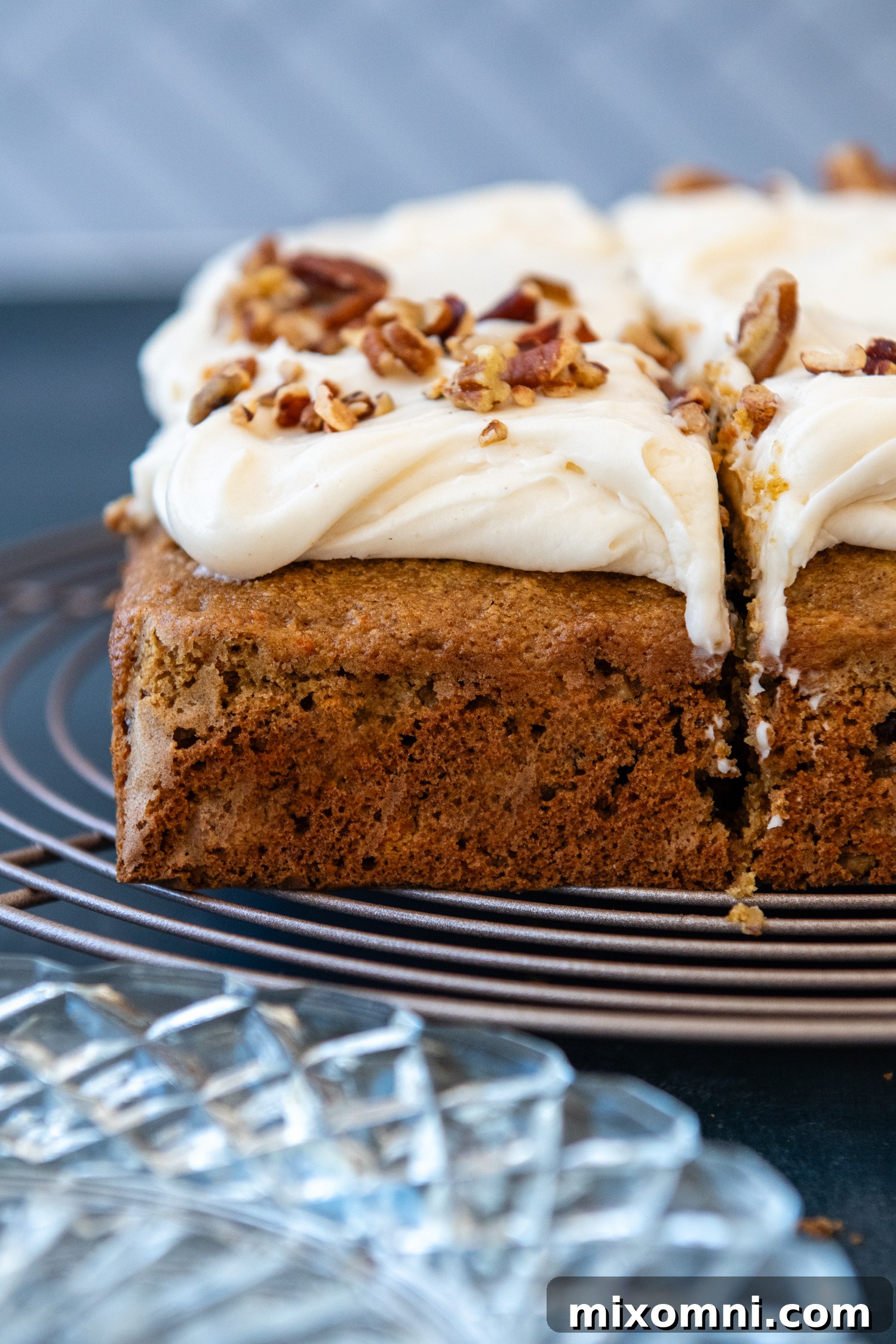 A beautifully frosted gluten-free oat flour carrot cake resting on a wire rack, ready to be served and impress guests.