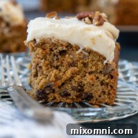 Slice of Oat Flour Carrot Cake sitting on a glass plate.