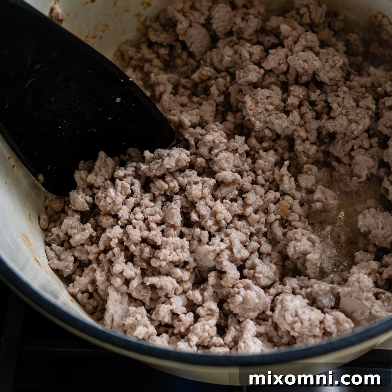 Ground pork being broken up and browned.