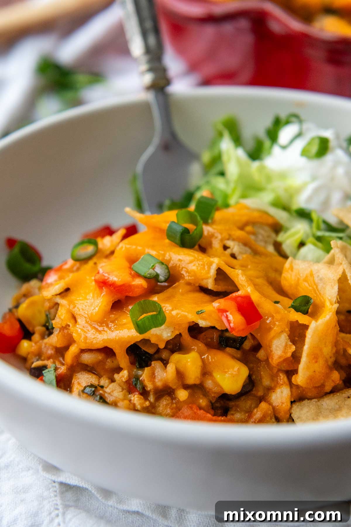 A generous serving of Mexican chicken rice casserole, garnished with fresh cilantro and a dollop of sour cream, presented in a rustic bowl.