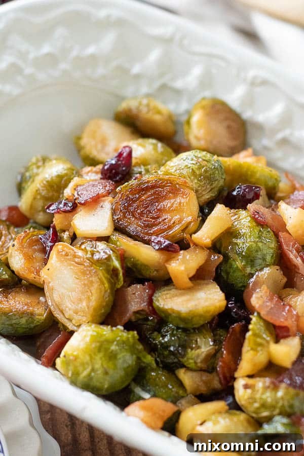 A close-up of bacon Brussels sprouts served in a rustic bowl, highlighting their glistening, caramelized surface and crispy bacon bits.