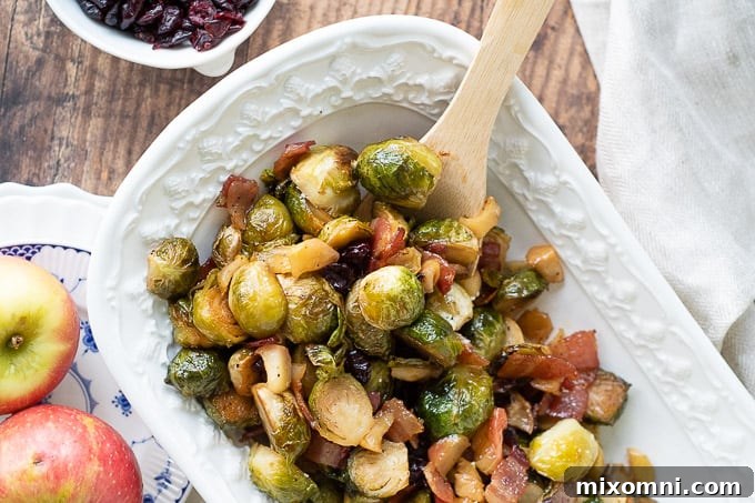 Bacon Brussels sprouts elegantly presented in a white serving bowl, with a wooden spoon nestled in for serving, emphasizing their rustic charm.
