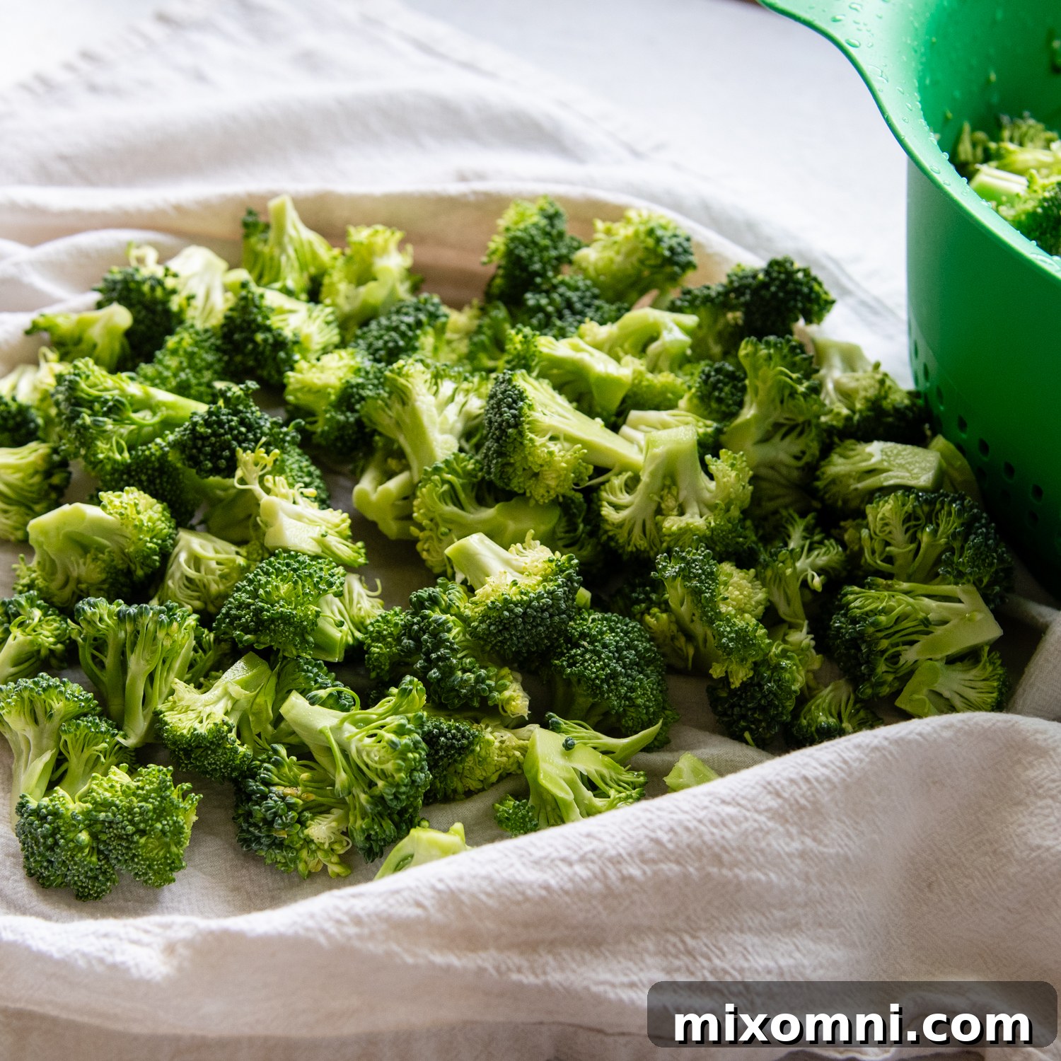 Fresh broccoli florets drying on a towel.