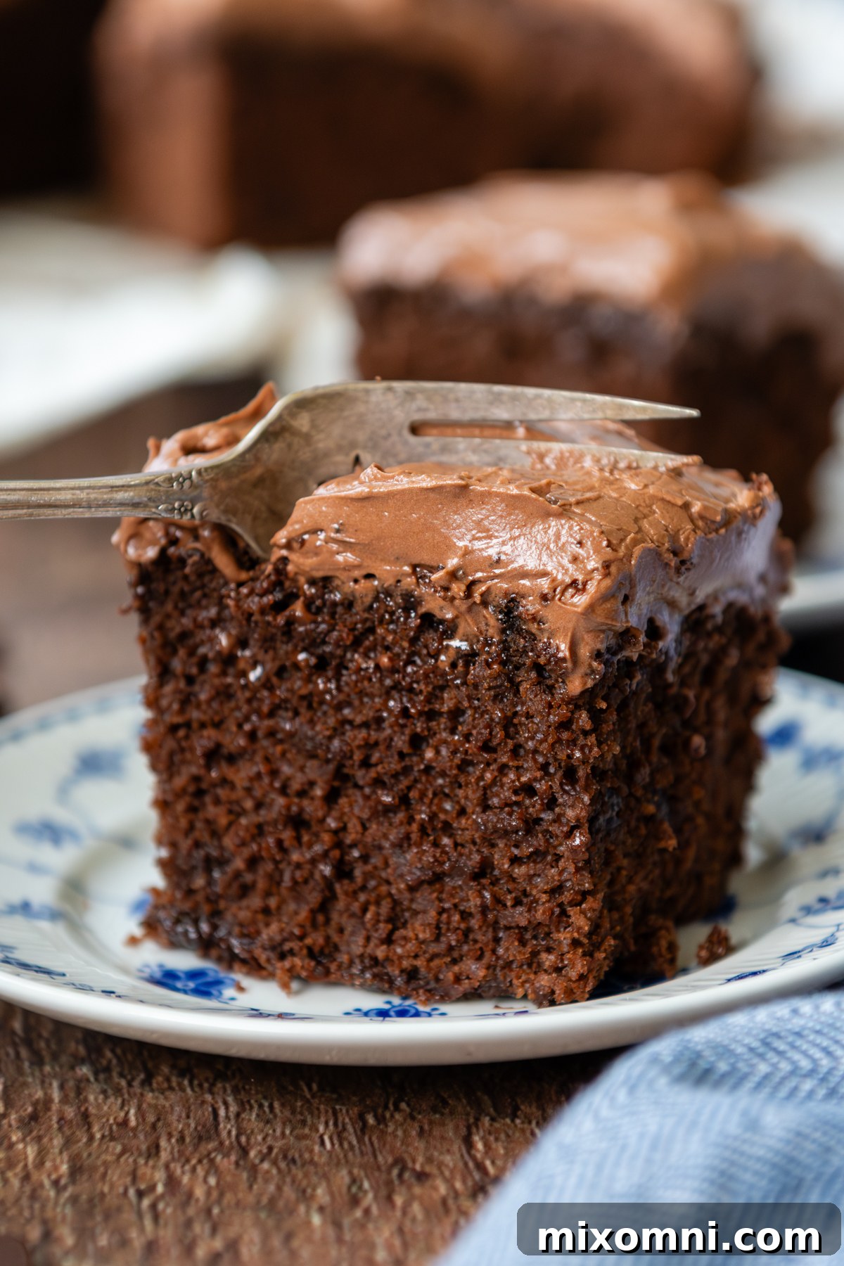 A delectable slice of oat flour chocolate cake resting on a glass plate, with a fork poised to take a bite.