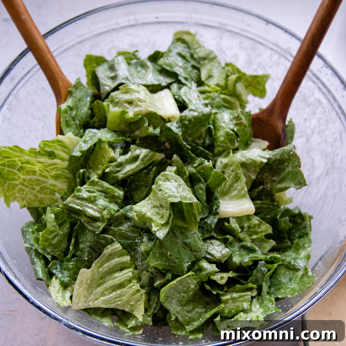 Fresh hearts of romaine lettuce being prepared in a large glass bowl.