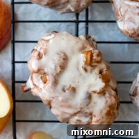 Gluten free apple fritter covered in glaze sitting on a drying rack.