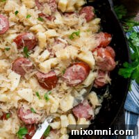 Gluten free dumplings and sausage with sauerkraut in a cast iron skillet.