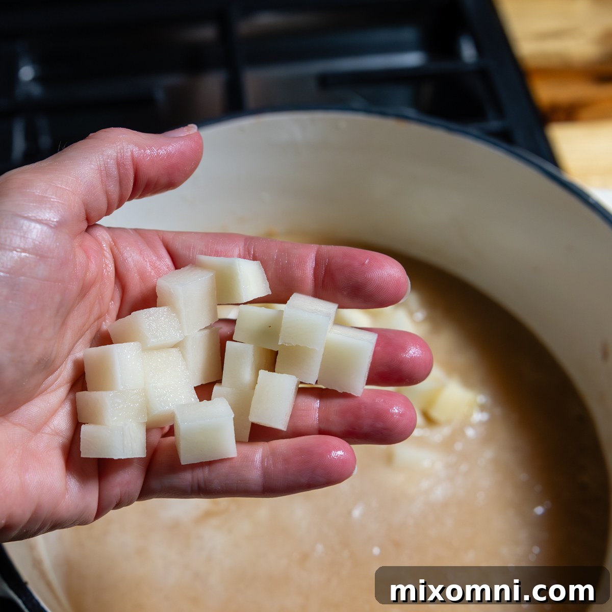 Hand showing size of of potato after being cut.