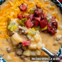 Overhead shot of gluten free cheeseburger soup in a bowl with a spoon.