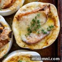 Overhead shot of French Onion Soup in a white soup crock topped with parsley.