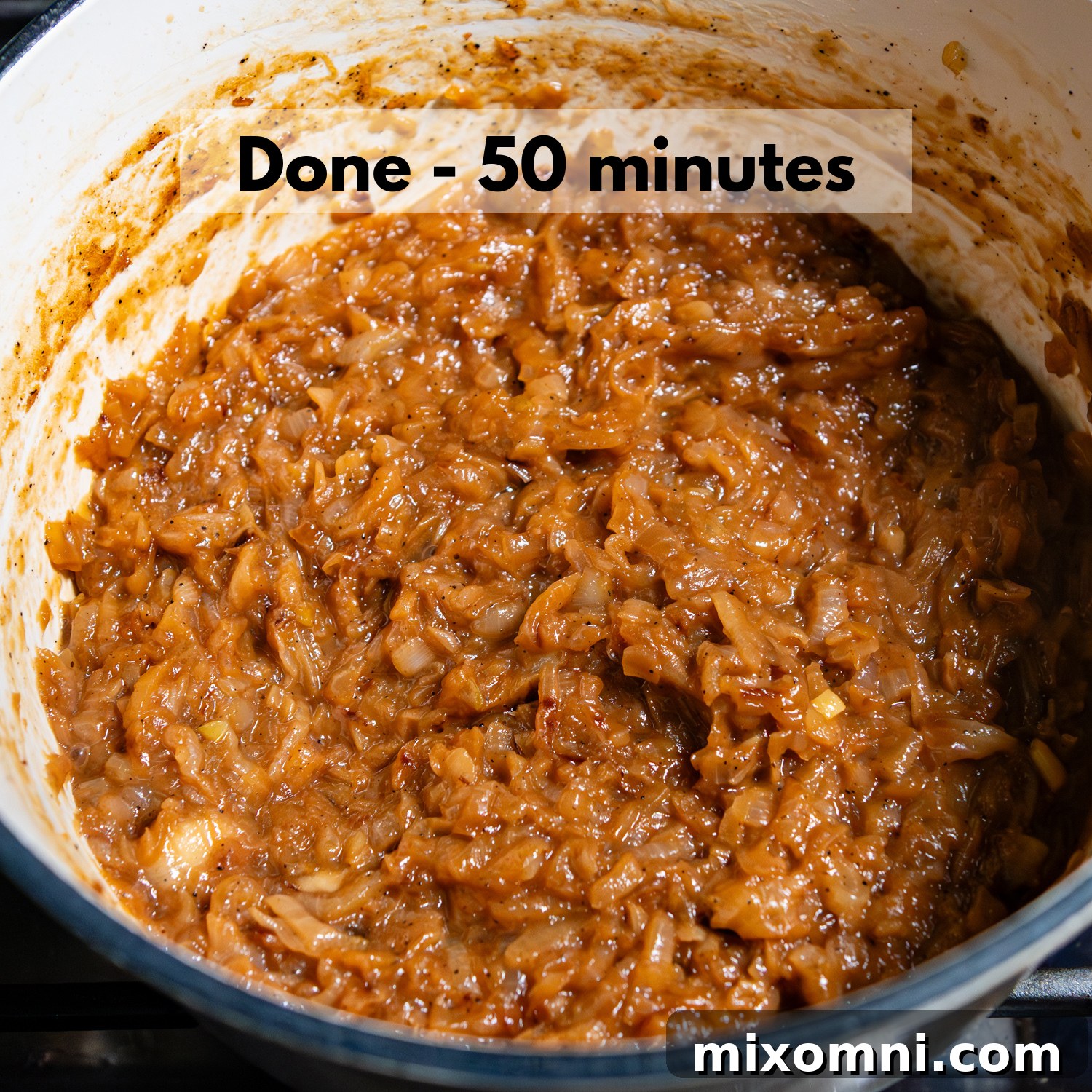 Image of fully caramelized onions in a pot after 50 minutes of cooking, showing a deep, even golden-brown color and soft, jam-like texture, indicating they are perfectly done.