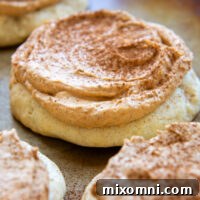 A Gluten-Free Pumpkin Cream Cookie frosted and sprinkled with cinnamon, showcasing its fluffy topping and soft base.