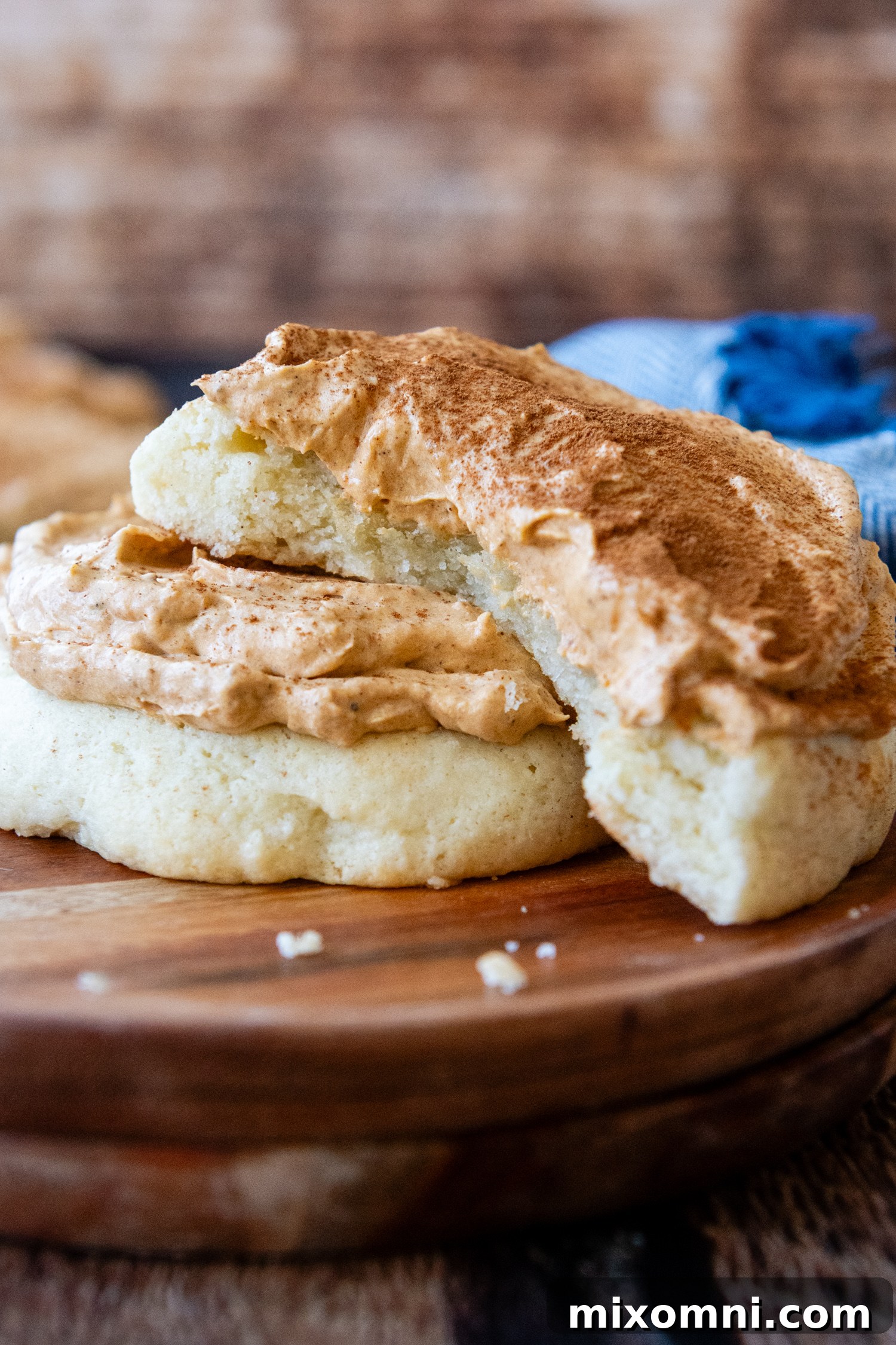 A beautifully frosted gluten-free pumpkin cream pie cookie, ready to be enjoyed, with a soft sugar cookie base visible.