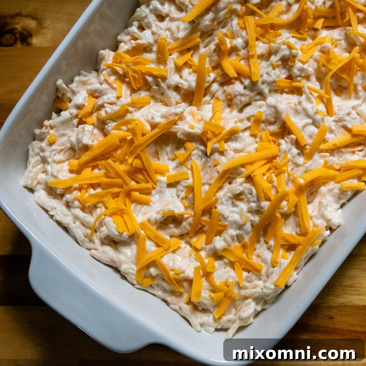 Uncooked combined casserole ingredients in a white baking dish.
