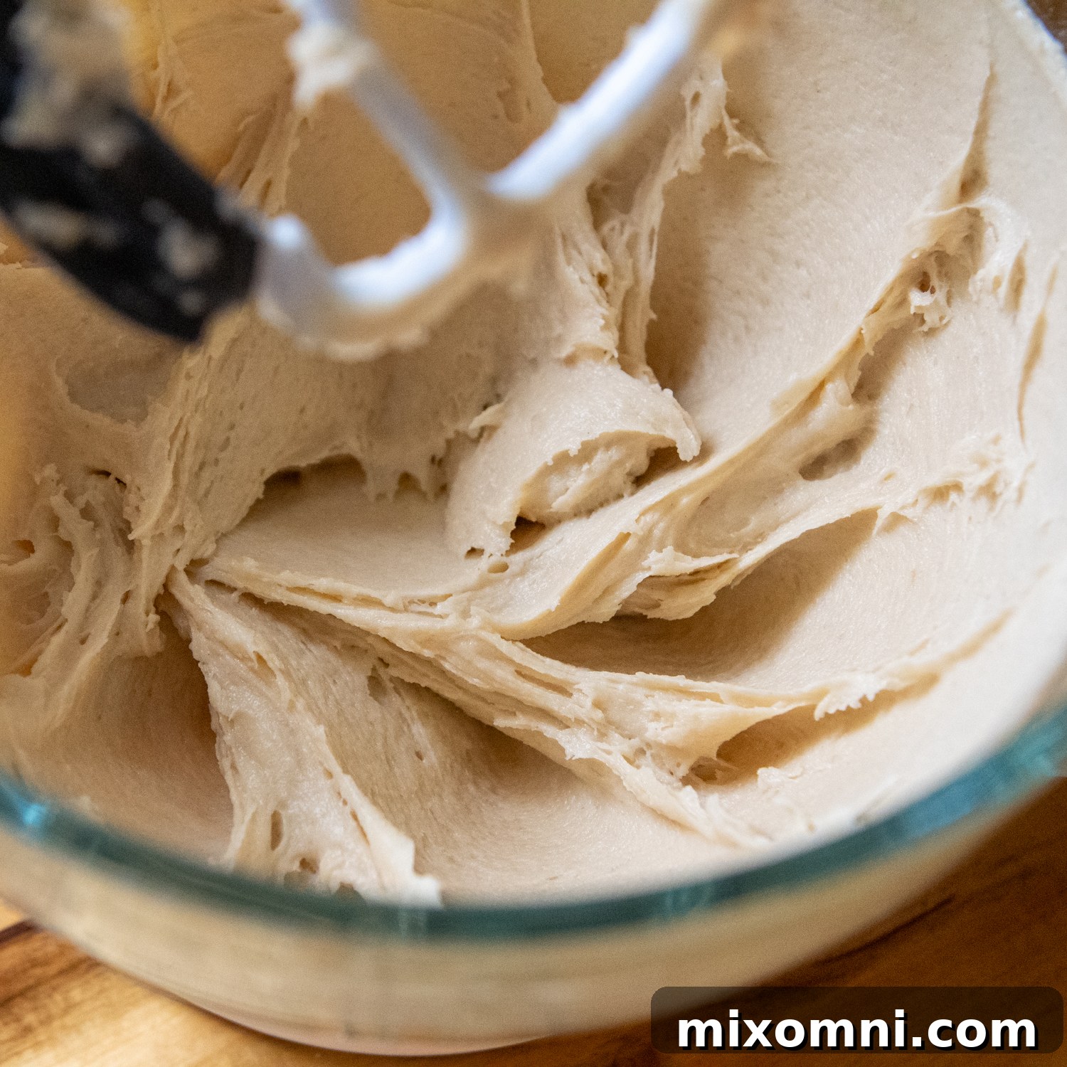 Combined dry and wet ingredients forming a stiff, slightly sticky dough in a glass mixing bowl, ready for shaping.