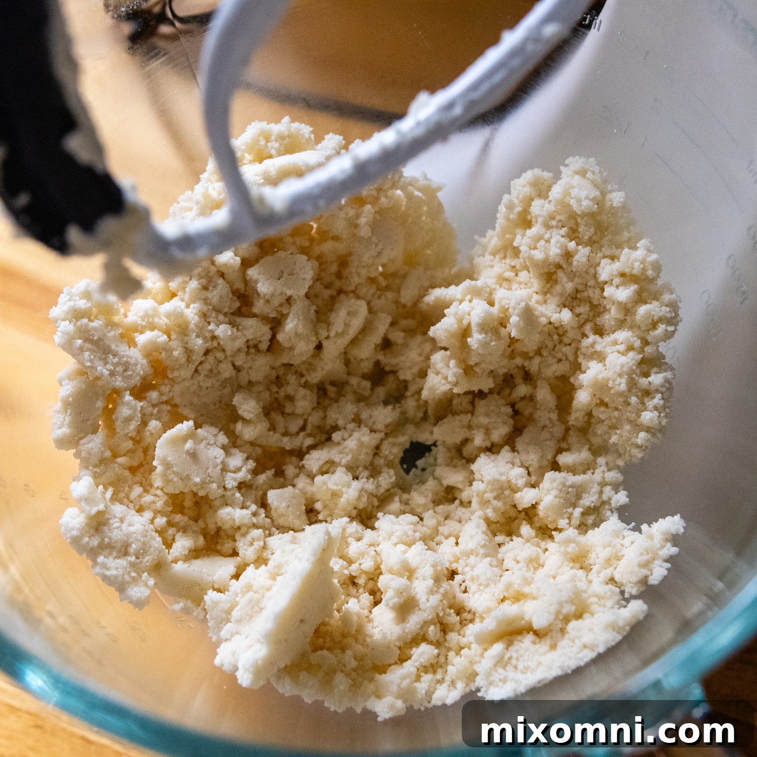 Shortbread mixture clumped together in a glass mixing bowl, before adding egg yolk.