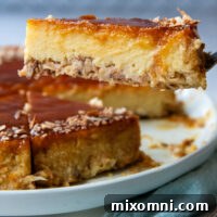 A piece of coconut flan being lifted off of a white plate by a fork.