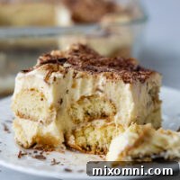 A slice of tiramisu with a bite taken out of it.