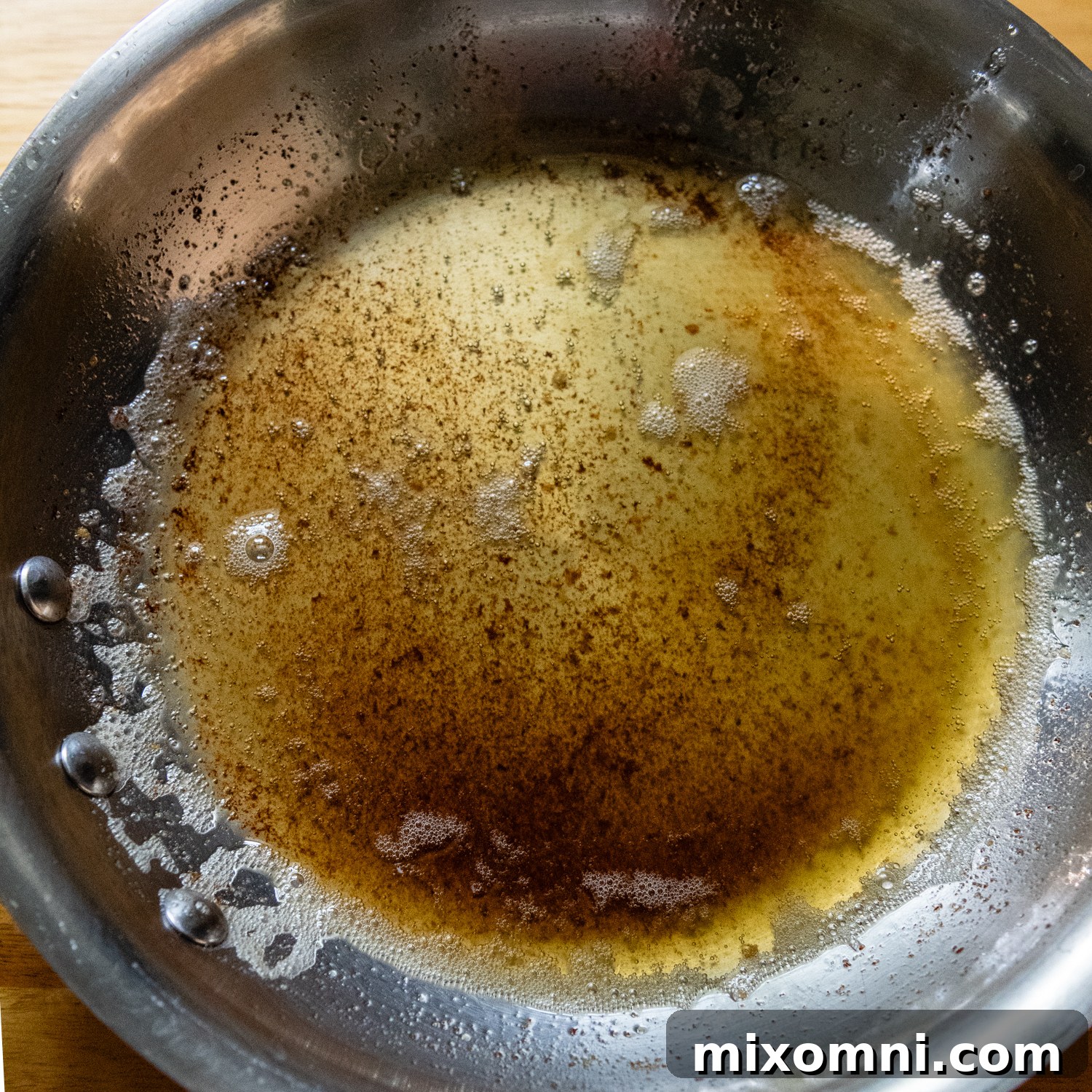 Browned butter shimmering in a small silver pan, showcasing its rich golden-amber color and nutty aroma.