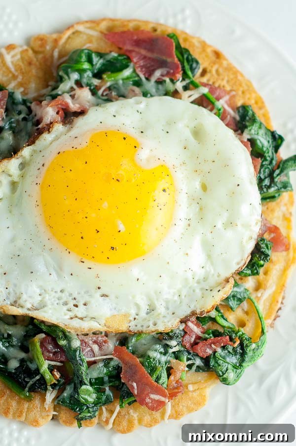 Overhead shot of a gourmet Farinata pizza topped with spinach, egg, and prosciutto on a white plate, ready to be enjoyed.