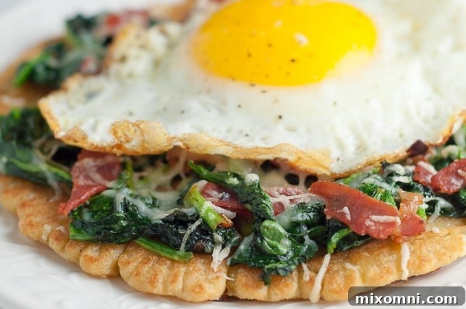 A close-up view of the rich spinach and crispy prosciutto topping on a gluten-free Farinata pizza.