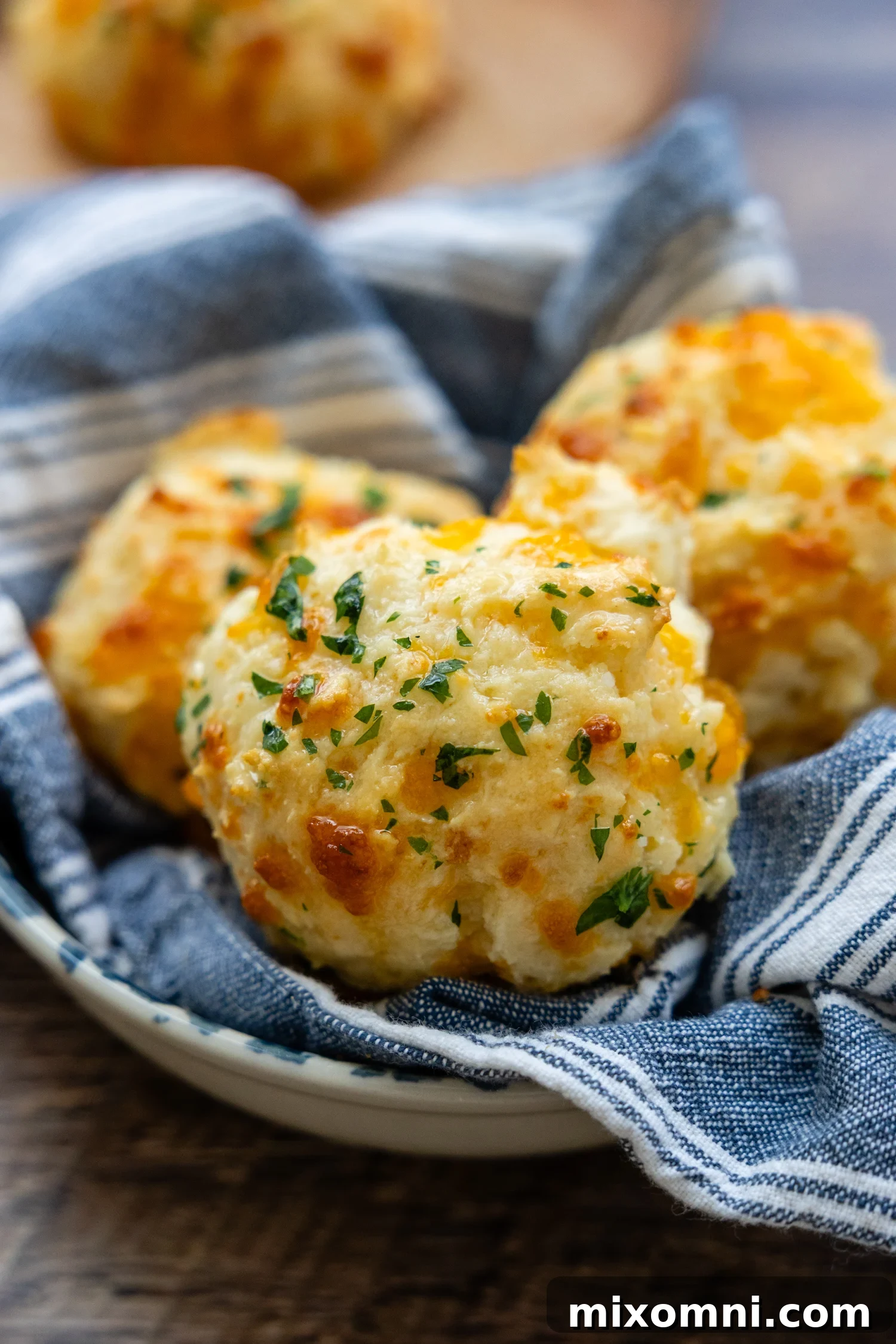 A plate of golden-brown gluten-free cheddar biscuits, perfectly baked and ready to be enjoyed.