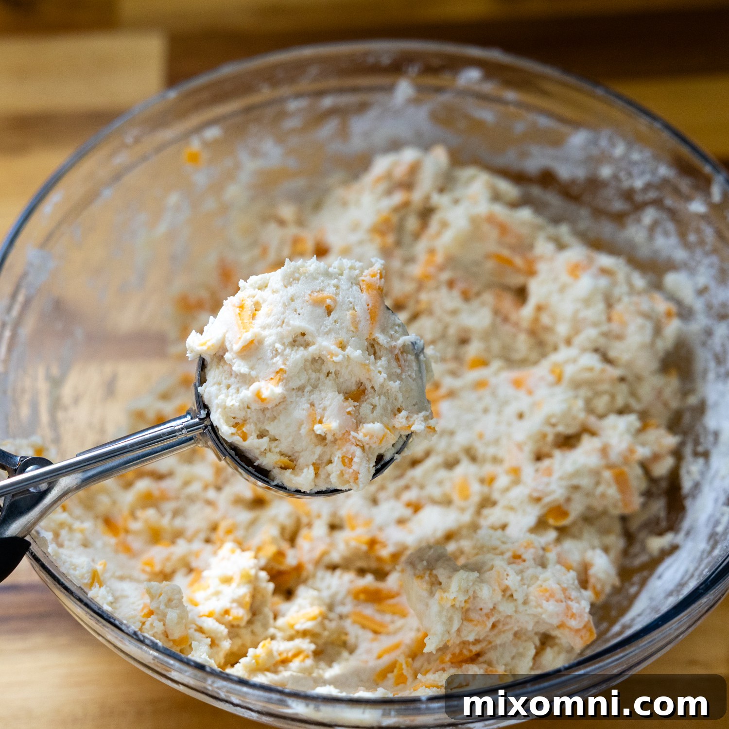 Wet and dry biscuit ingredients mixed together in a bowl, forming a soft dough.