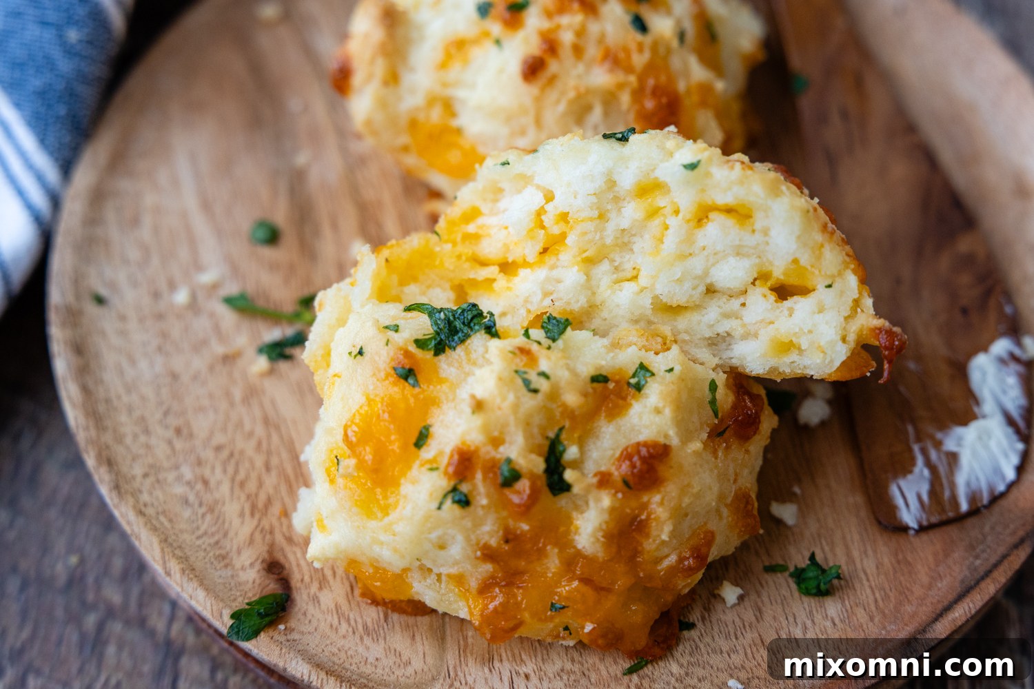 A close-up shot of two gluten-free cheese biscuits, one cut in half to show the soft, tender interior.