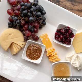 second step of how to make a charcuterie board - adding cheeses