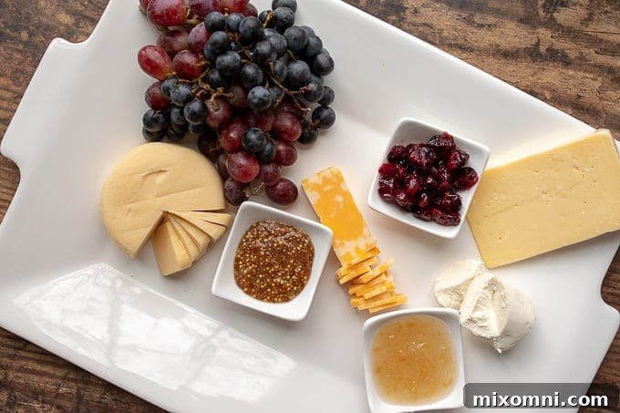 second step of how to make a charcuterie board - adding cheeses