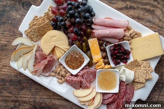 an overhead shot of a charcuterie board with plates nearby